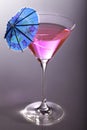 Party girl. Pink party cocktail with blue umbrella Royalty Free Stock Photo